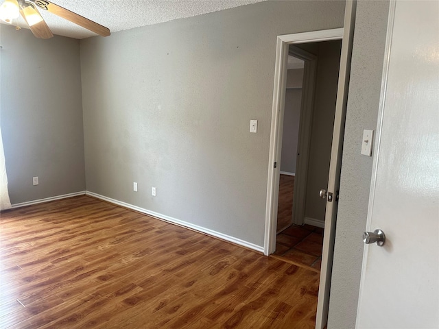 empty room featuring hardwood / wood-style floors, ceiling fan, and a textured ceiling