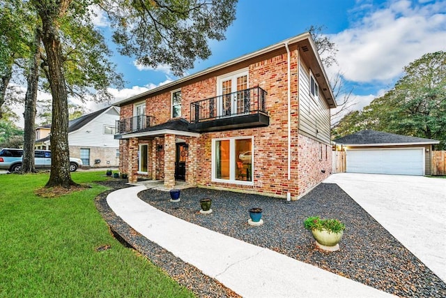 view of front of property featuring a balcony, a front lawn, an outbuilding, and a garage