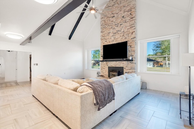 living room with beam ceiling, ceiling fan, high vaulted ceiling, and a healthy amount of sunlight