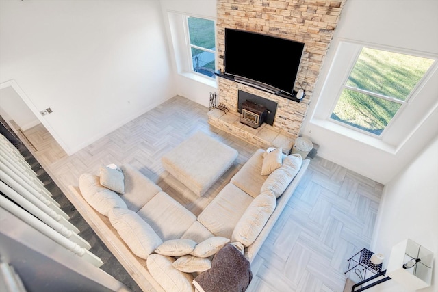 living room with a wood stove, plenty of natural light, and parquet floors