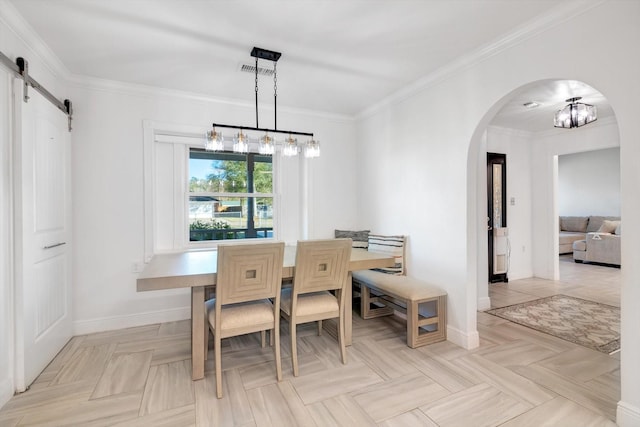 dining room with a chandelier, a barn door, ornamental molding, and light parquet flooring