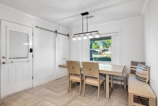 dining space featuring a barn door, ornamental molding, and light parquet flooring