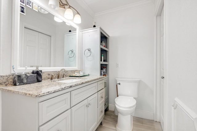 bathroom featuring vanity, toilet, and ornamental molding