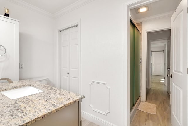 bathroom with hardwood / wood-style floors, vanity, ornamental molding, and walk in shower