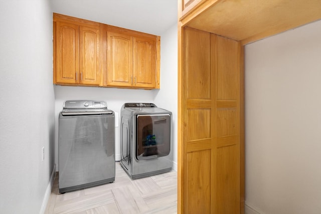 laundry room with washing machine and dryer and cabinets