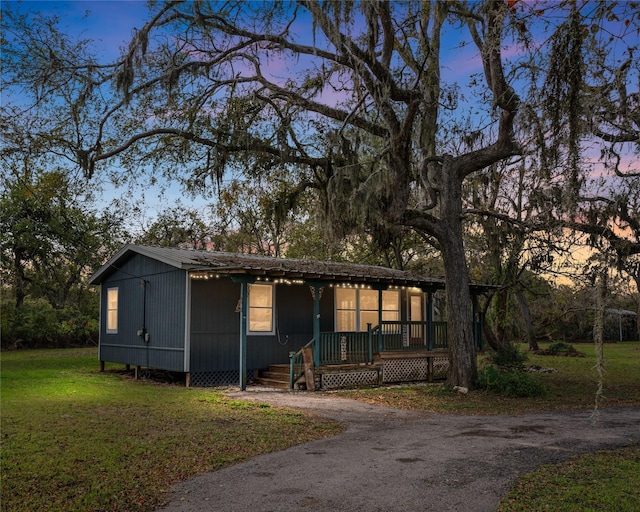 view of front of home with a porch and a yard