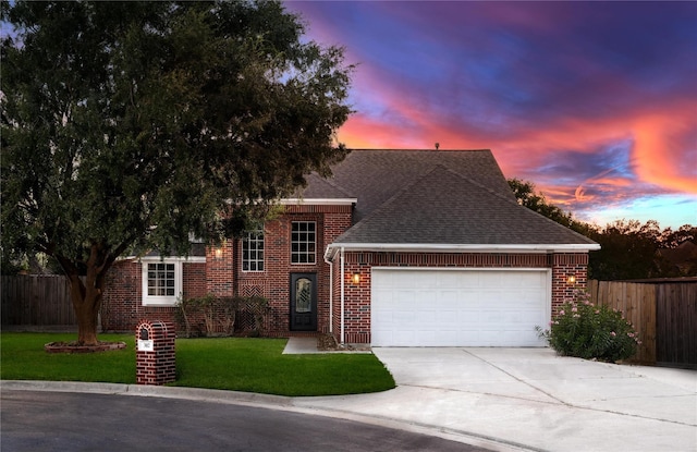 view of front of home with a garage and a yard