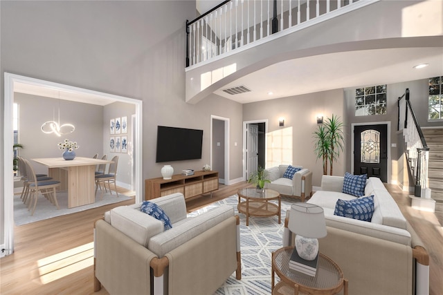 living room featuring light hardwood / wood-style floors and a high ceiling