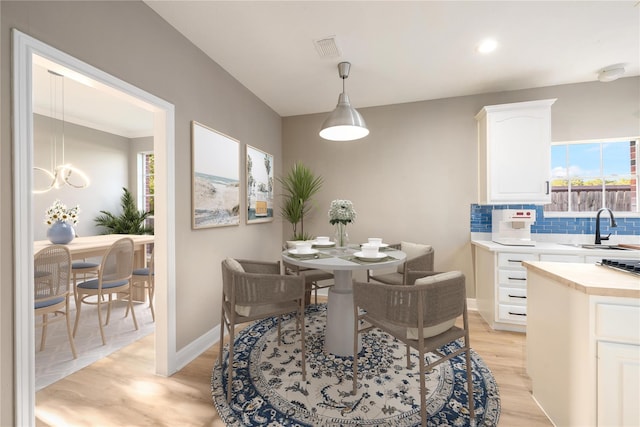 dining area with a wealth of natural light, sink, and light hardwood / wood-style floors