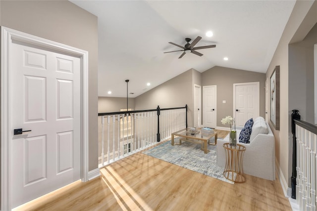 living area with ceiling fan, light hardwood / wood-style floors, and lofted ceiling