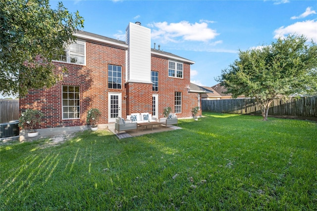 back of property with a patio area, a yard, and an outdoor living space