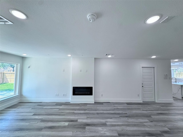 unfurnished living room featuring hardwood / wood-style floors and sink