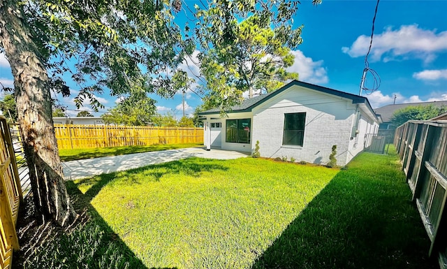 rear view of house with a yard and a patio