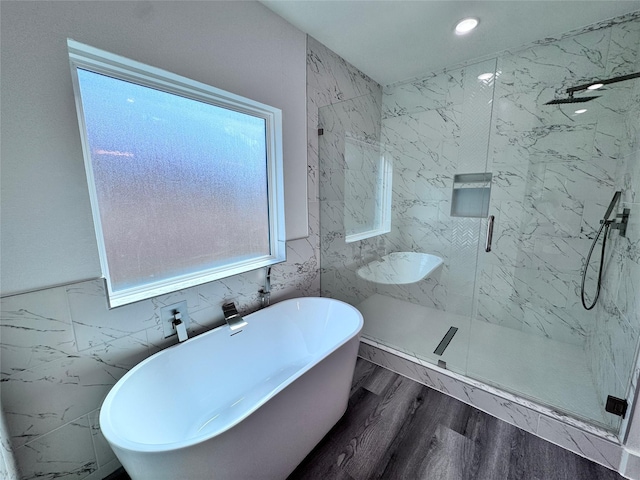 bathroom featuring wood-type flooring, tile walls, and independent shower and bath