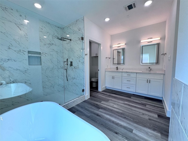 full bathroom with toilet, vanity, wood-type flooring, and shower with separate bathtub