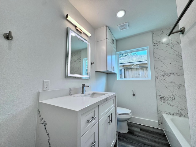 full bathroom featuring wood-type flooring, vanity, toilet, and tiled shower / bath