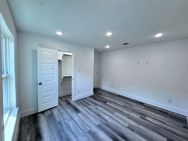 unfurnished bedroom with a closet and dark hardwood / wood-style floors