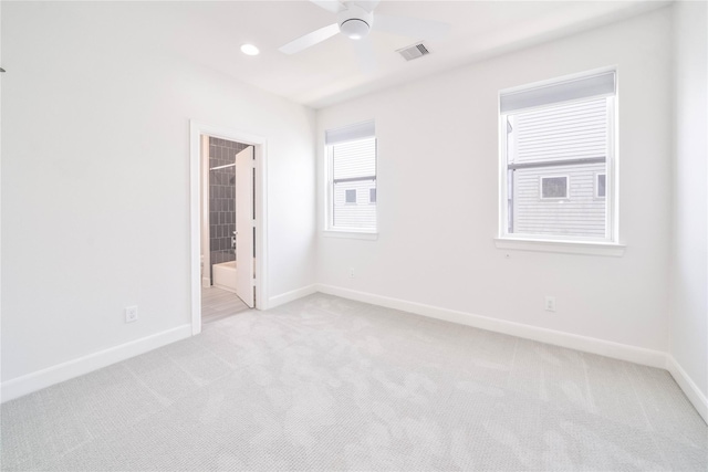 unfurnished bedroom with ensuite bath, ceiling fan, and light carpet