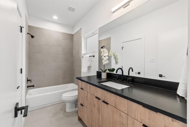 full bathroom with tile patterned floors, vanity, tiled shower / bath combo, and toilet