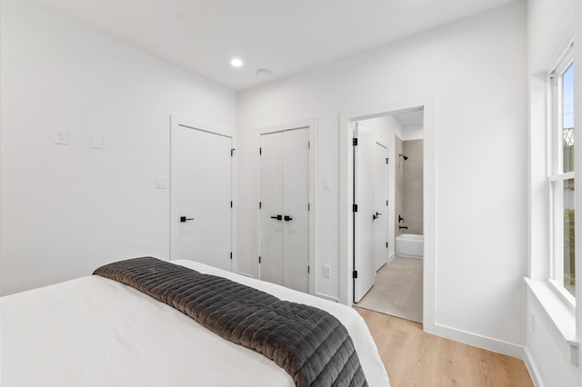 bedroom with light hardwood / wood-style flooring and ensuite bath