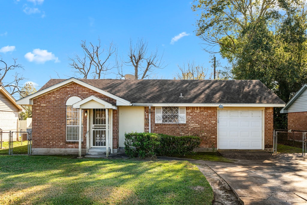 ranch-style house with a garage and a front lawn