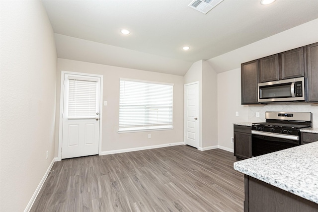 kitchen with dark brown cabinetry, light hardwood / wood-style flooring, lofted ceiling, decorative backsplash, and appliances with stainless steel finishes