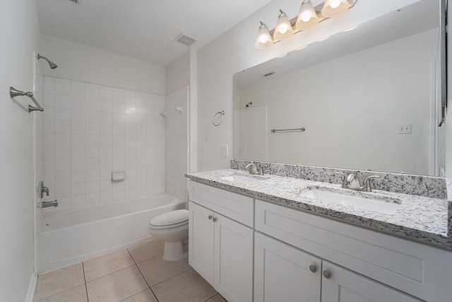 full bathroom with tiled shower / bath, vanity, tile patterned floors, and toilet