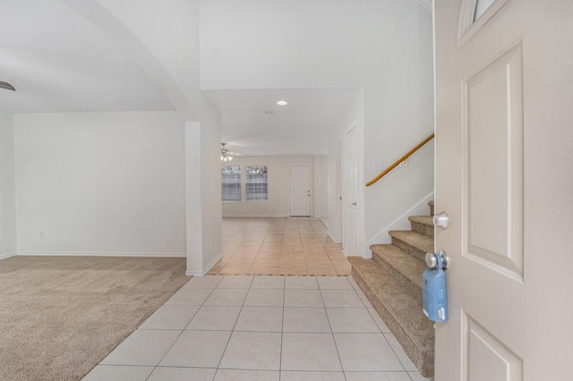 entrance foyer with ceiling fan and light colored carpet