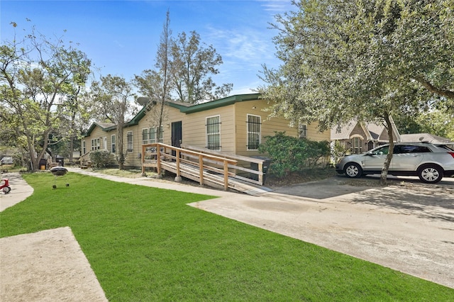 view of front facade with a wooden deck and a front lawn