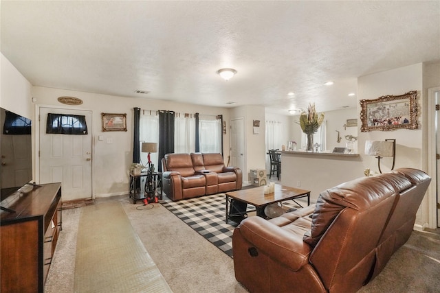 carpeted living room featuring a textured ceiling