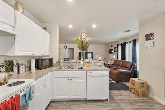 kitchen with sink, kitchen peninsula, white dishwasher, light hardwood / wood-style floors, and white cabinets