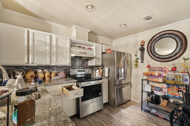 kitchen featuring light stone countertops, appliances with stainless steel finishes, tasteful backsplash, white cabinets, and range hood