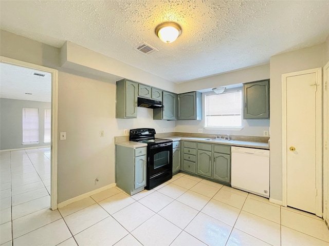 kitchen with electric range, dishwasher, sink, green cabinets, and light tile patterned floors