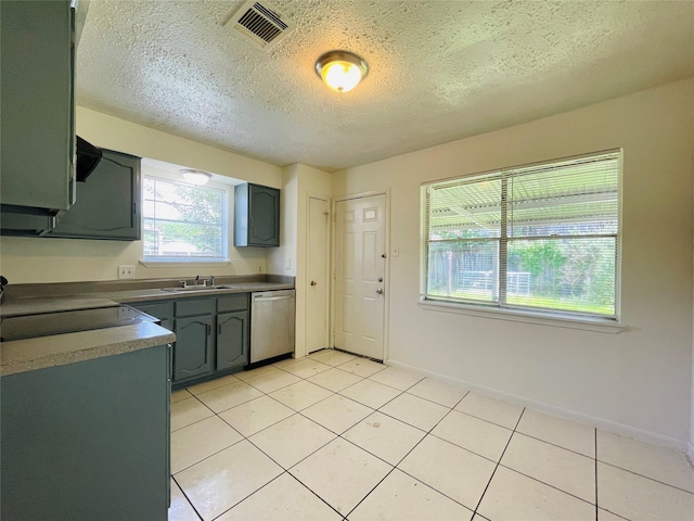 kitchen with sink, stainless steel dishwasher, a textured ceiling, light tile patterned floors, and range