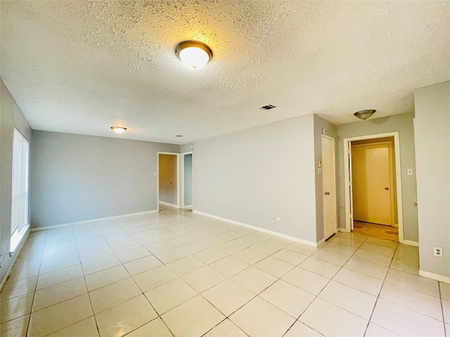 unfurnished room featuring light tile patterned floors and a textured ceiling