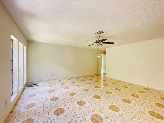 spare room featuring a wealth of natural light, ceiling fan, and a textured ceiling