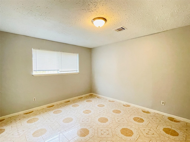 unfurnished room featuring a textured ceiling