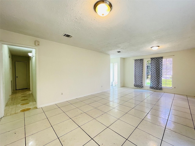 tiled spare room with a textured ceiling