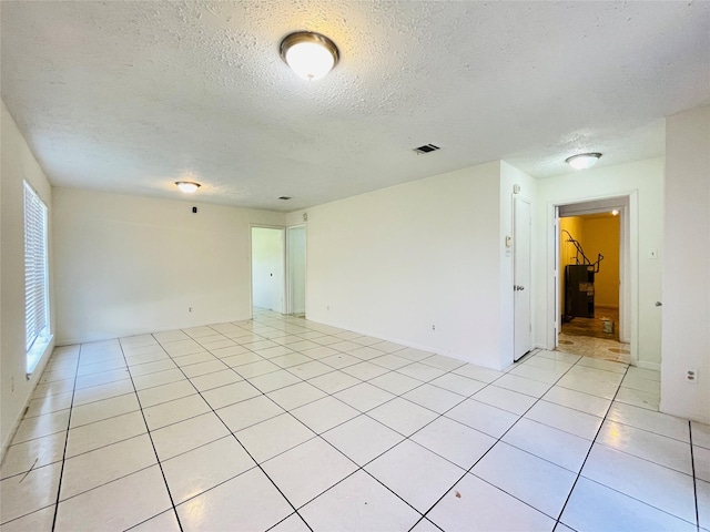 tiled spare room featuring a textured ceiling