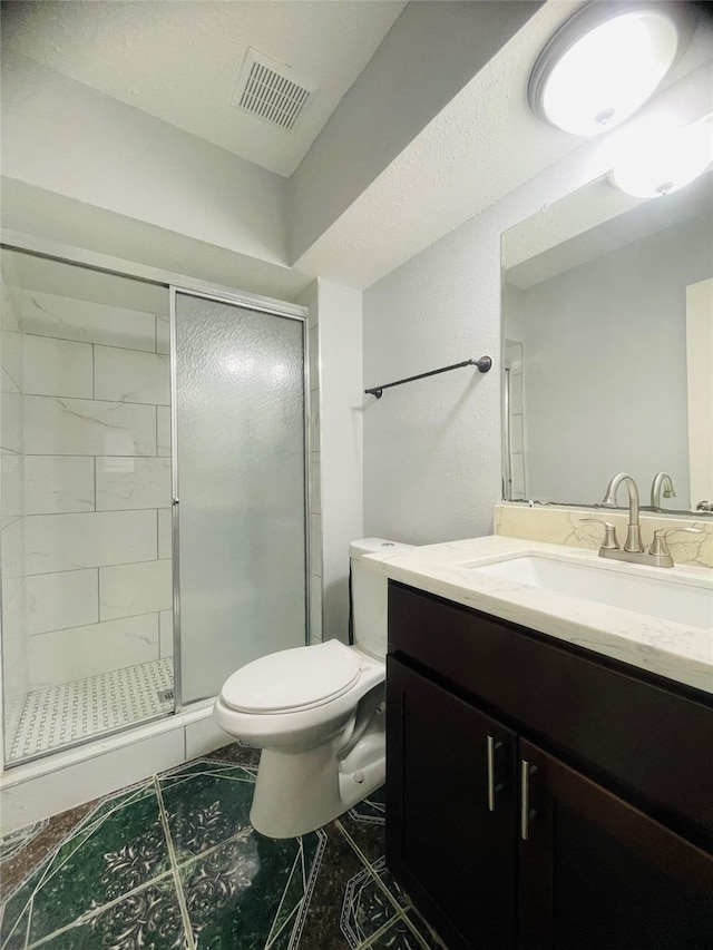 bathroom featuring vanity, toilet, and a shower with shower door