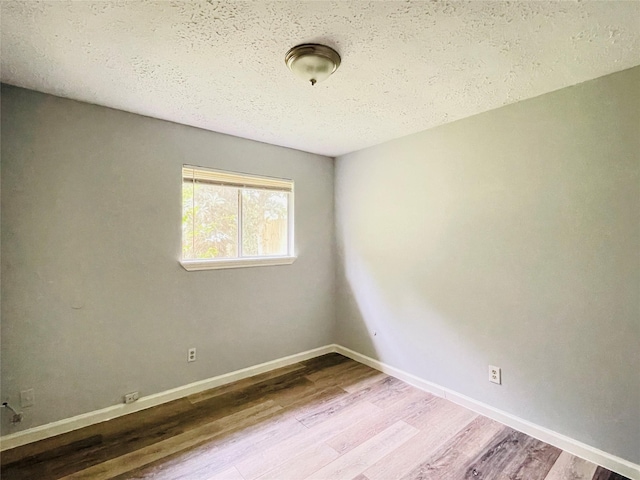 spare room with hardwood / wood-style flooring and a textured ceiling