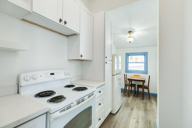 kitchen featuring light stone counters, white cabinets, light hardwood / wood-style floors, and white appliances