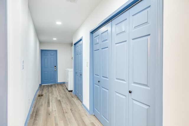 hall featuring independent washer and dryer and light hardwood / wood-style flooring