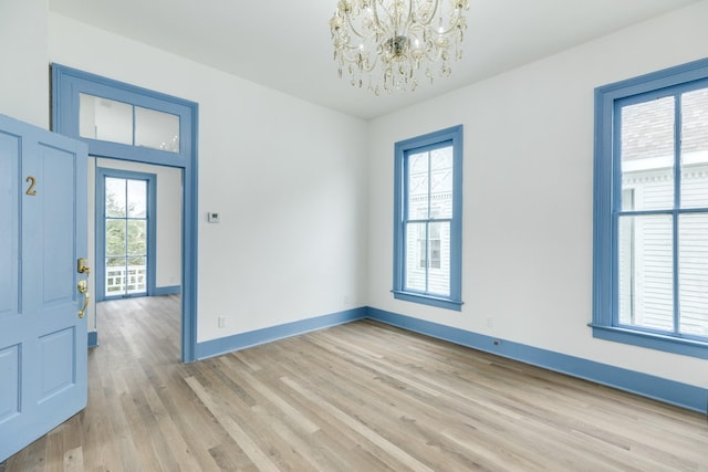 foyer entrance featuring light hardwood / wood-style floors and an inviting chandelier