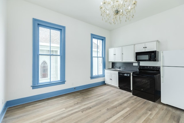 kitchen with a chandelier, white cabinets, black appliances, and light hardwood / wood-style floors