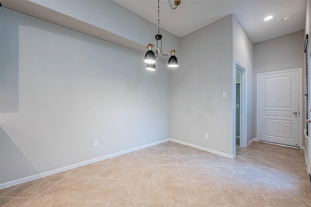 spare room featuring light tile patterned flooring and an inviting chandelier