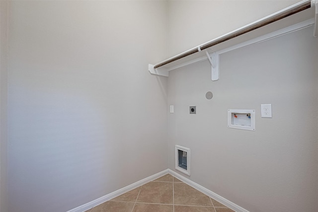 clothes washing area with hookup for an electric dryer, hookup for a washing machine, gas dryer hookup, and light tile patterned flooring