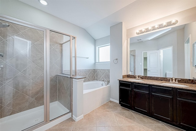 bathroom with tile patterned floors, vanity, separate shower and tub, and vaulted ceiling