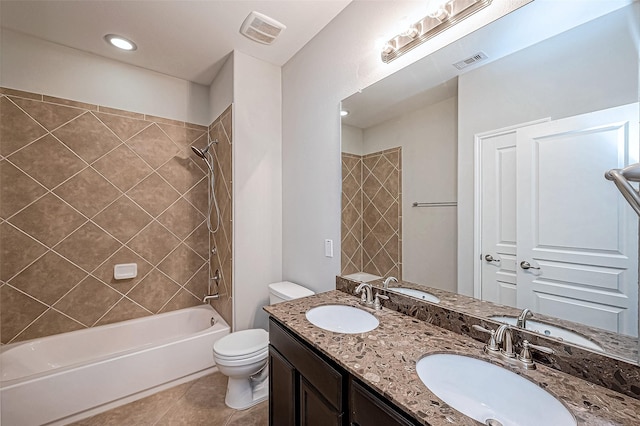 full bathroom featuring vanity, tile patterned flooring, tiled shower / bath, and toilet