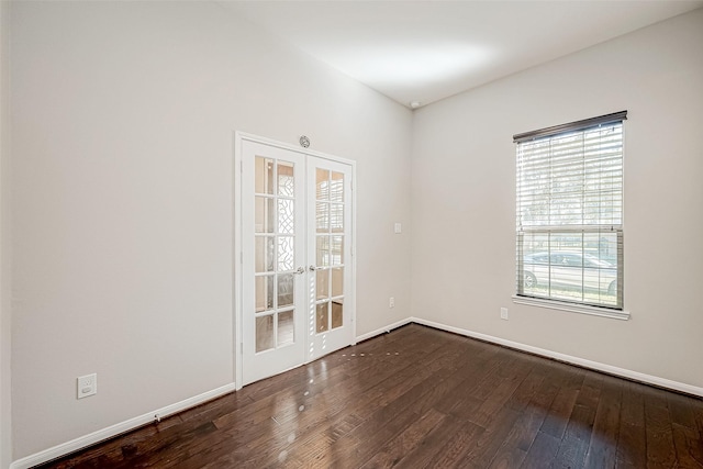 spare room featuring french doors and dark wood-type flooring